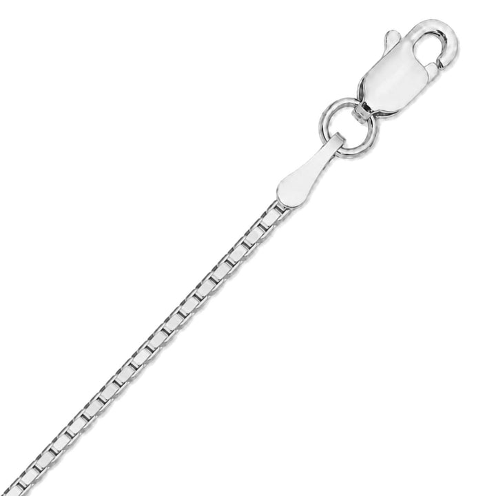 A close up image of a white gold box chain on a pure white background