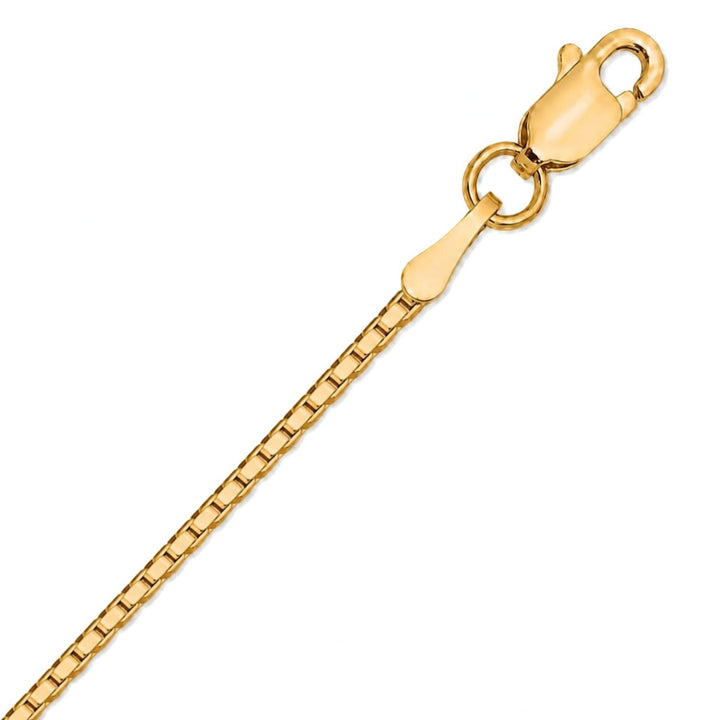 A close up image of a yellow gold box chain on a pure white background
