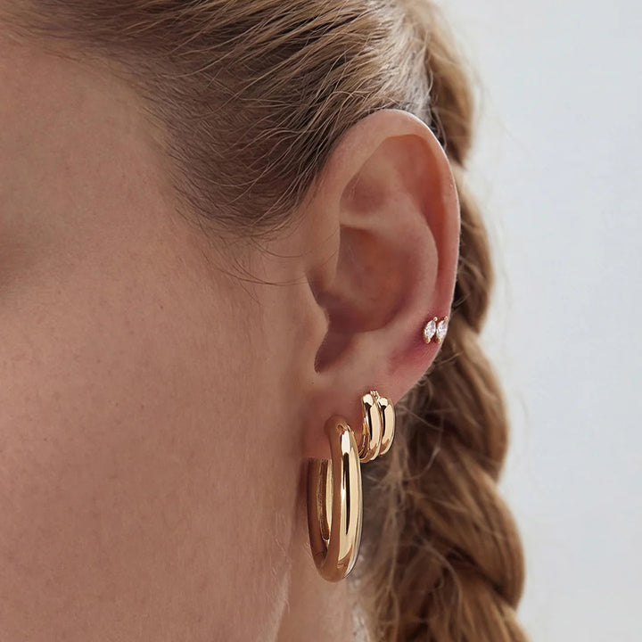 Model wearing the 14K yellow gold double marquise lab grown diamond stud earrings with layered fine jewelry | AJ's Jewelry