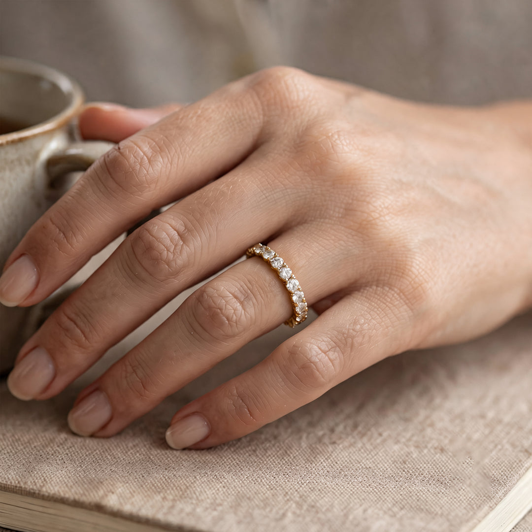 14 karat yellow gold lab grown diamond eternity band worn on a hand at AJ's Jewelry in Ridgewood, Queens NY