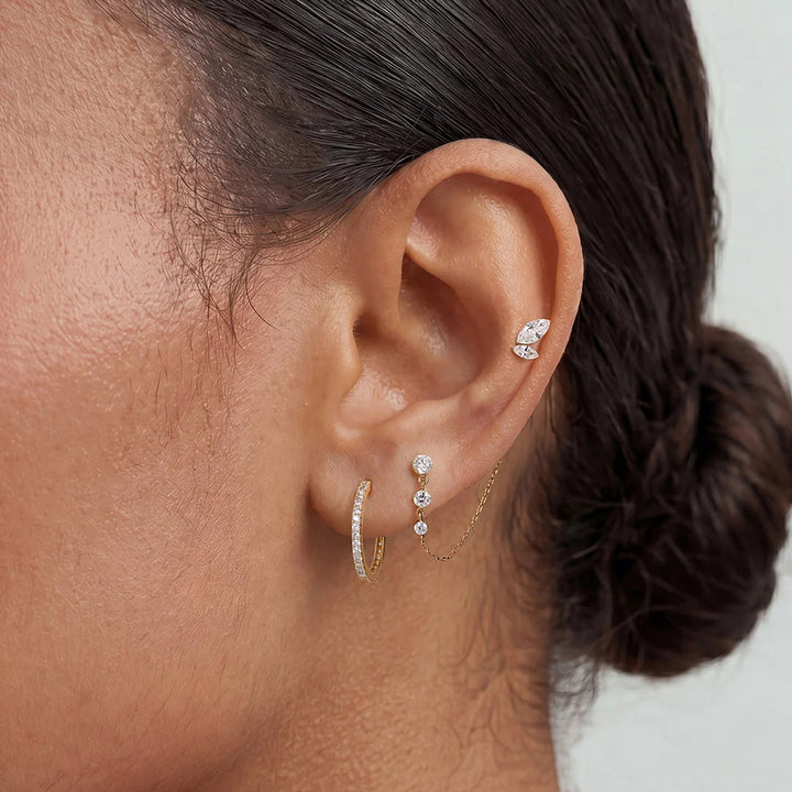 Model wearing the 14K yellow gold marquise lab grown diamond leaf flat back stud earrings in a styled ear stack | AJ's Jewelry