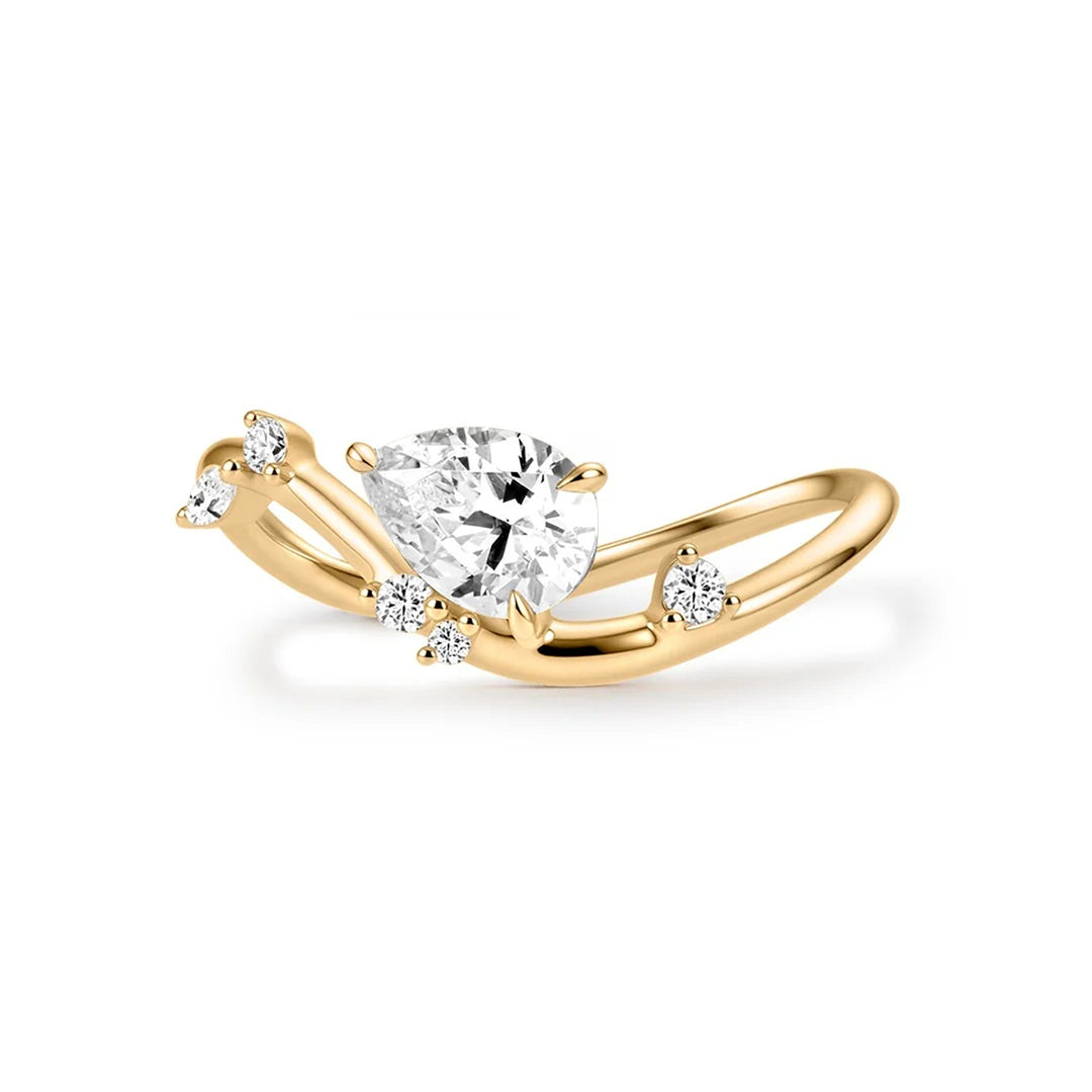 14K yellow gold curved engagement ring with a pear-shaped lab grown diamond and scattered lab grown diamond accents