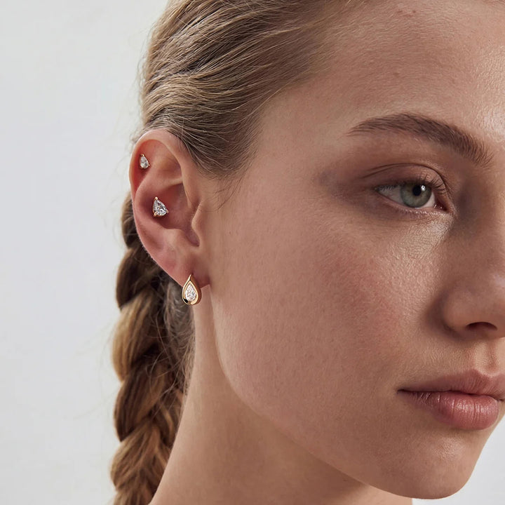 Model wearing the 14K yellow gold pear lab grown diamond stud earrings with layered fine jewelry | AJ's Jewelry