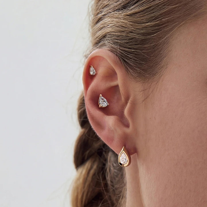 The 14K yellow gold pear lab grown diamond stud earrings worn on the ear, side view | AJ's Jewelry