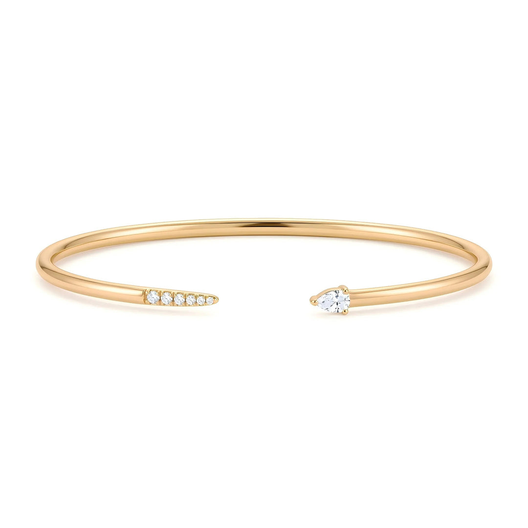 14K yellow gold open bangle bracelet with a pear-shaped lab grown diamond and a tapering row of round lab grown diamonds