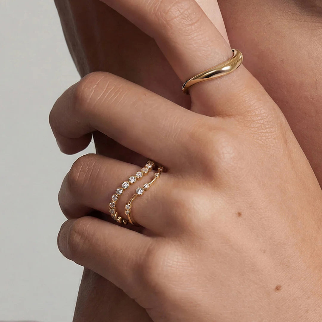 Close-up of the 14K yellow gold polished curved wave band ring worn on the hand | AJ's Jewelry