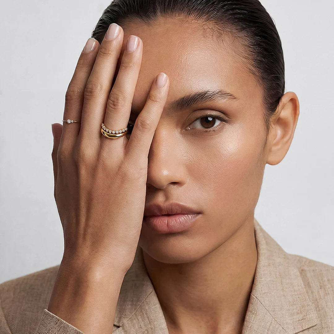 The 14K yellow gold polished curved wave band ring shown on a model's hand | AJ's Jewelry