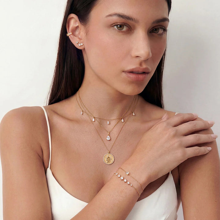 Model wearing the 14K yellow gold round lab grown diamond graduated line bracelet with layered fine jewelry | AJ's Jewelry