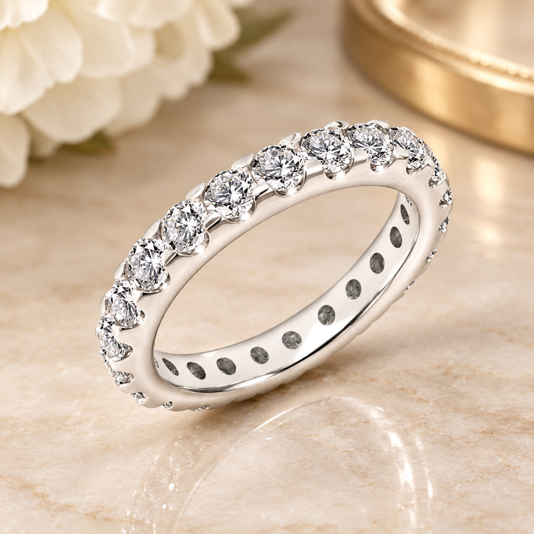 Styled angled photograph of the 14 karat white gold natural diamond eternity band on marble at AJ's Jewelry