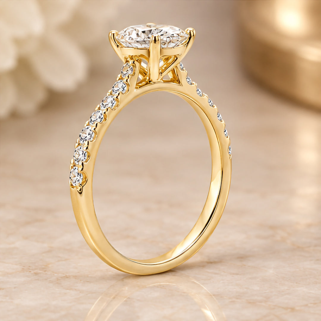Side profile of the 14 karat yellow gold oval lab grown diamond engagement ring showing the cathedral setting and diamond-set shoulders
