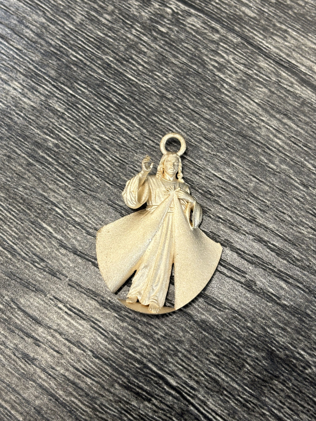 Raw gold casting of the Divine Mercy pendant before finishing — custom religious jewelry fabrication process at AJ's Jewelry Queens