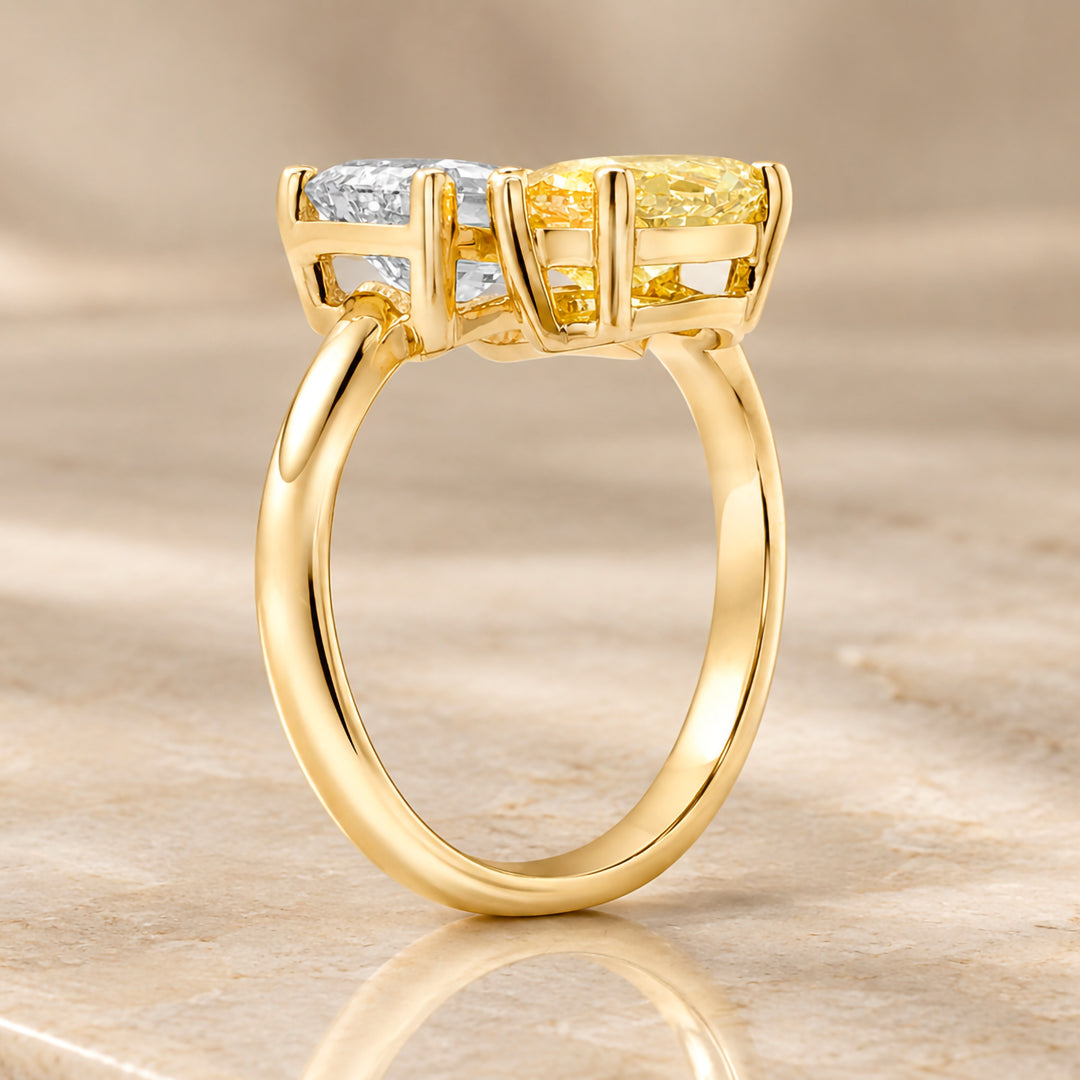 Side profile of the 14 karat yellow gold two-stone lab grown diamond engagement ring showing the prong setting and the bypass shank