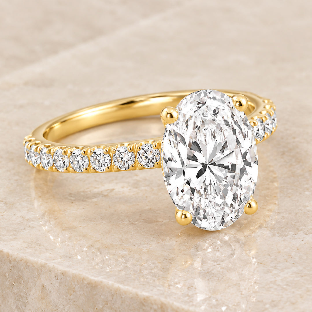 Angled view of the 18 karat yellow gold oval lab grown diamond engagement ring with a diamond band