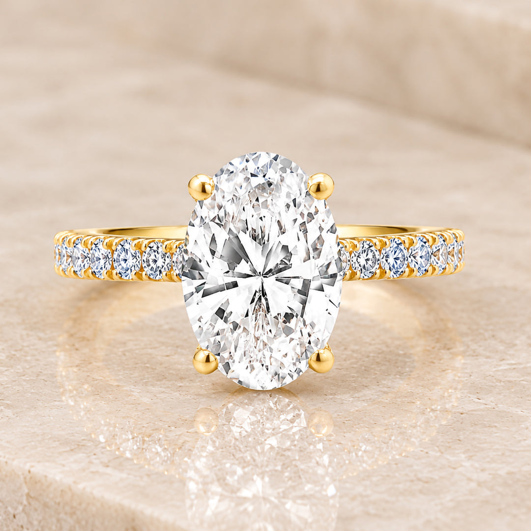 Front view of the oval lab grown diamond in its 18 karat yellow gold setting, reading as a clean solitaire from above