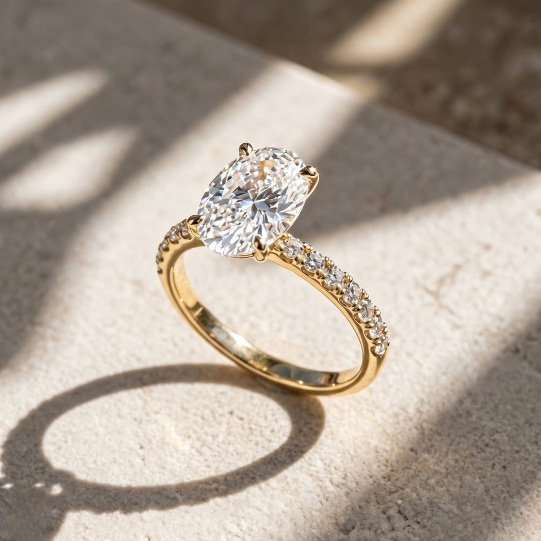 2 carat oval lab grown diamond pave engagement ring at an angle on a styled display at AJ's Jewelry Queens NY
