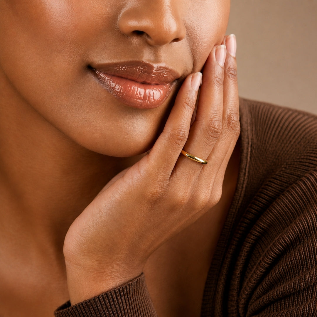 2mm 14K yellow gold comfort fit wedding band worn on a model's hand, close-up view - AJ's Jewelry, Ridgewood NY