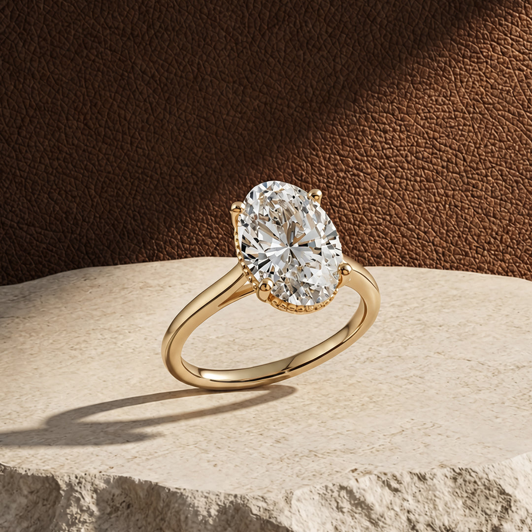 3ct oval lab grown diamond solitaire engagement ring with milgrain halo at an angle on a styled display - AJ's Jewelry Queens NY