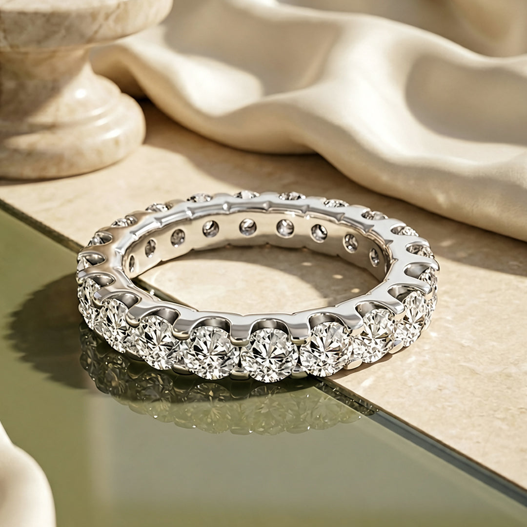 Custom 3 carat platinum lab-grown diamond eternity band shown from the front on a styled display at AJ's Jewelry in Ridgewood, Queens NY