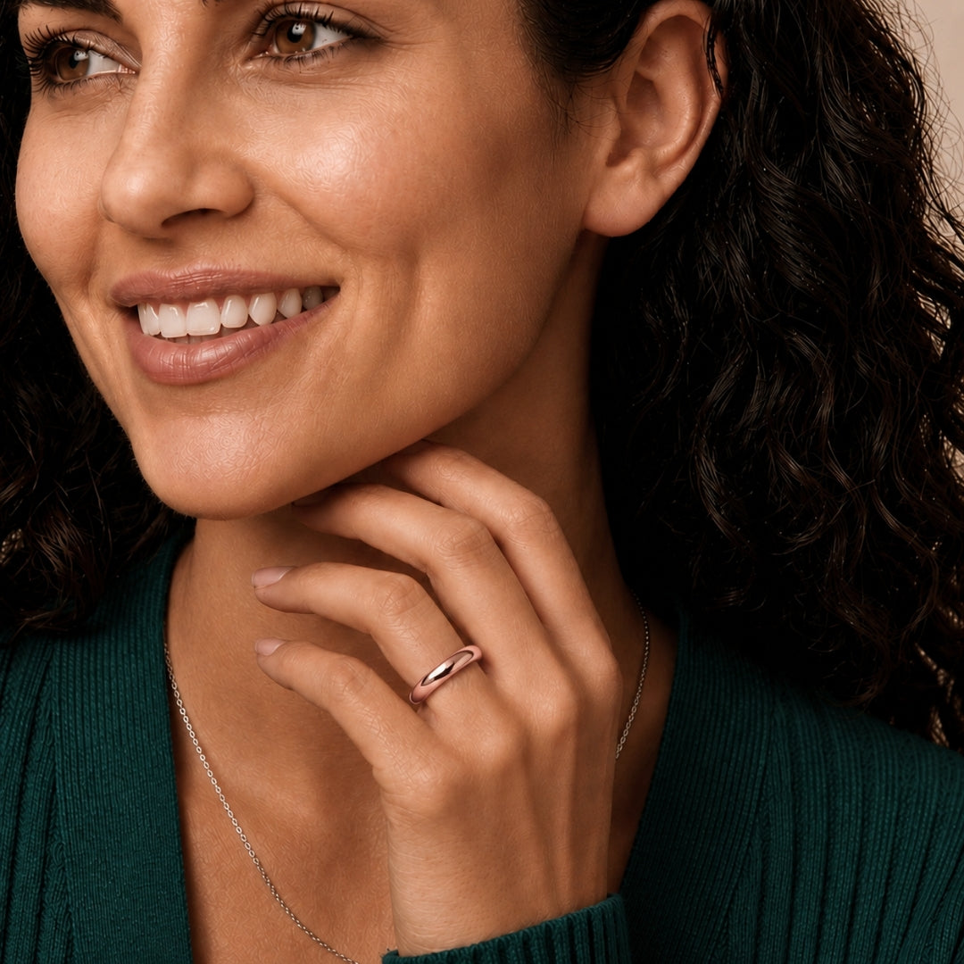 4mm 14K rose gold comfort fit wedding band worn on a model's hand, close-up view - AJ's Jewelry, Ridgewood NY