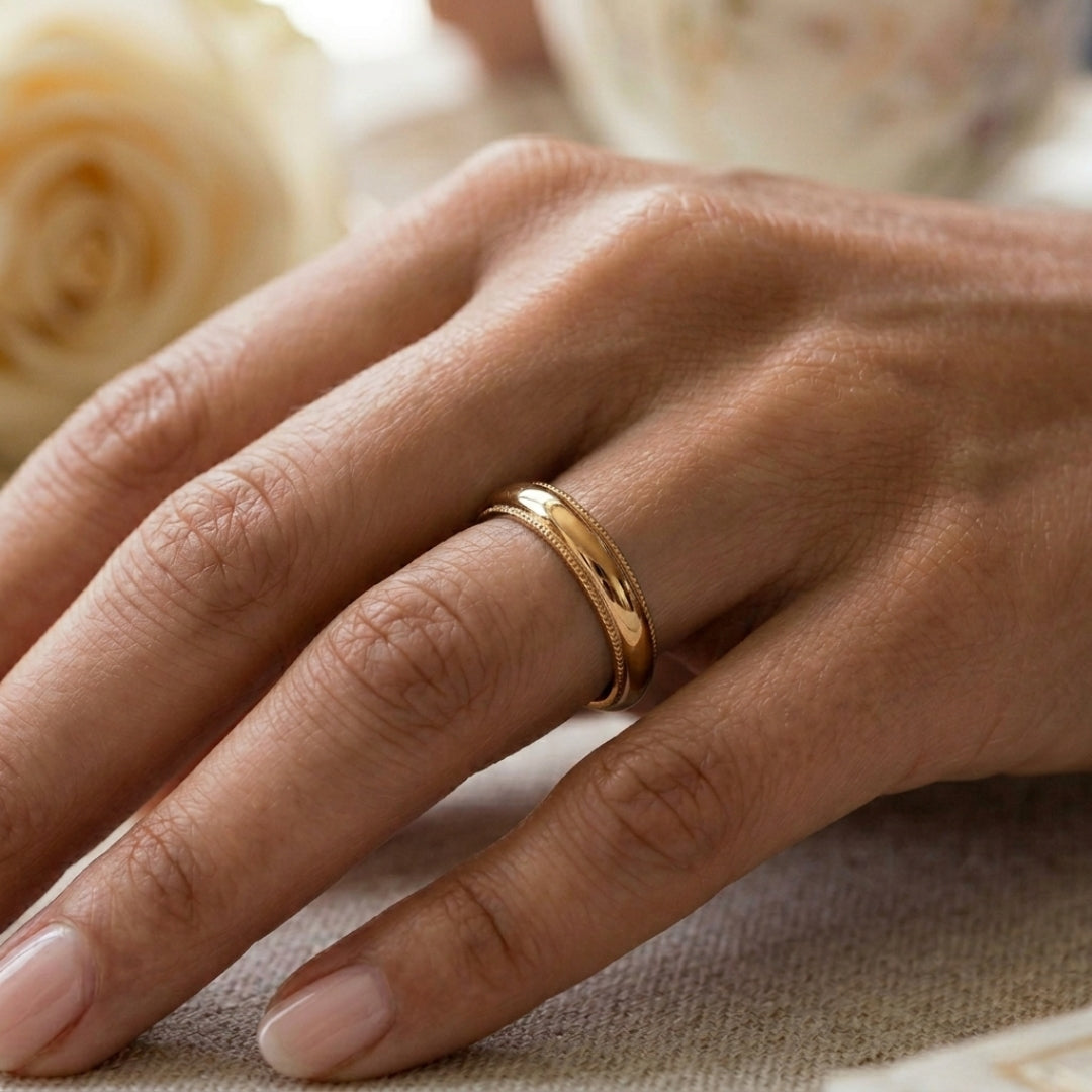 A model wearing the 4mm Yellow Gold Comfort Fit Milgrain Wedding Band