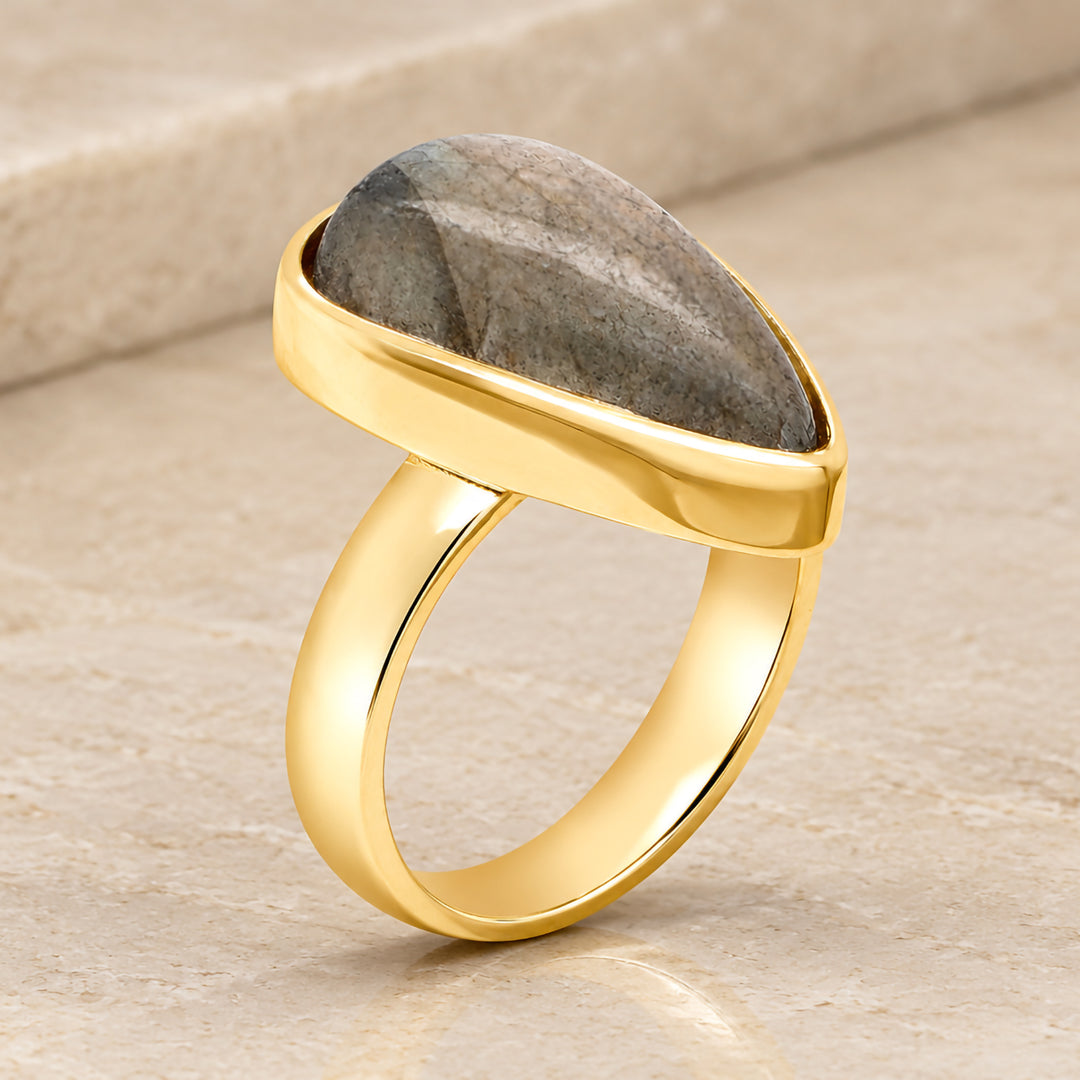 Profile view of the custom pear shaped labradorite ring showing the 14 karat yellow gold band beneath the mounting