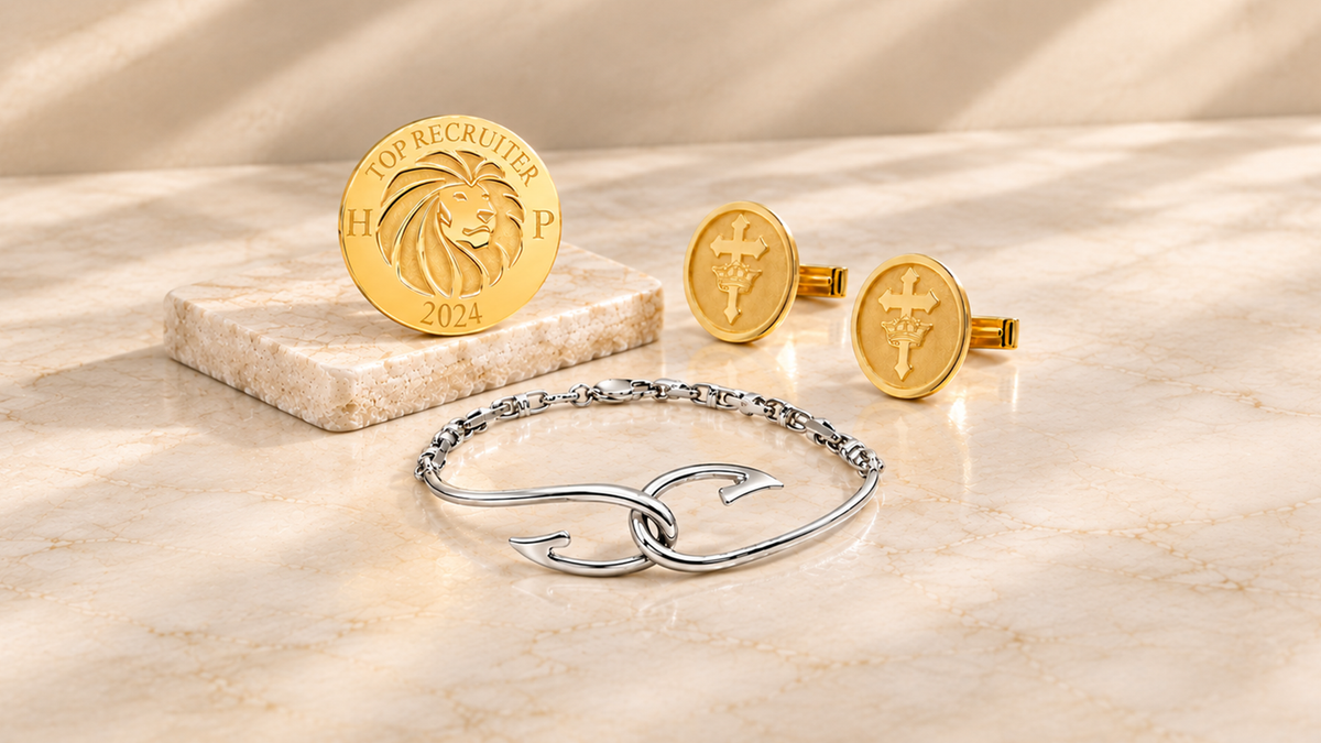 A image showing some of the custom bracelets and accessories done by AJ's Jewelry, including a corporate lapel pin, fish hook bracelet, and gold plated cufflinks on a luxury themed background