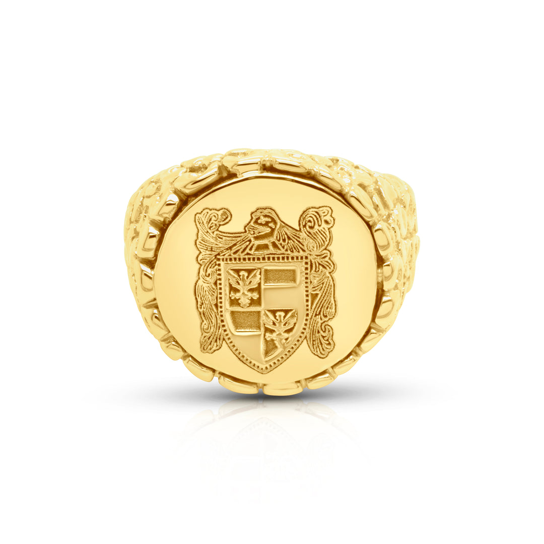 Gold signet ring with a detailed family crest emblem on a white background