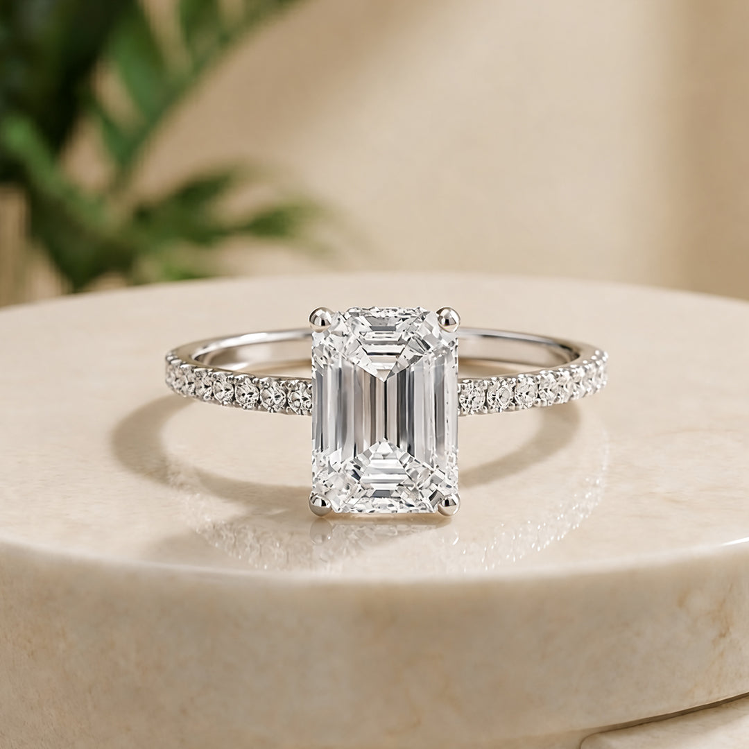 Custom 14KT white gold hidden halo emerald-shape lab-grown diamond engagement ring shown from the front on a styled display at AJ's Jewelry in Ridgewood, Queens NY
