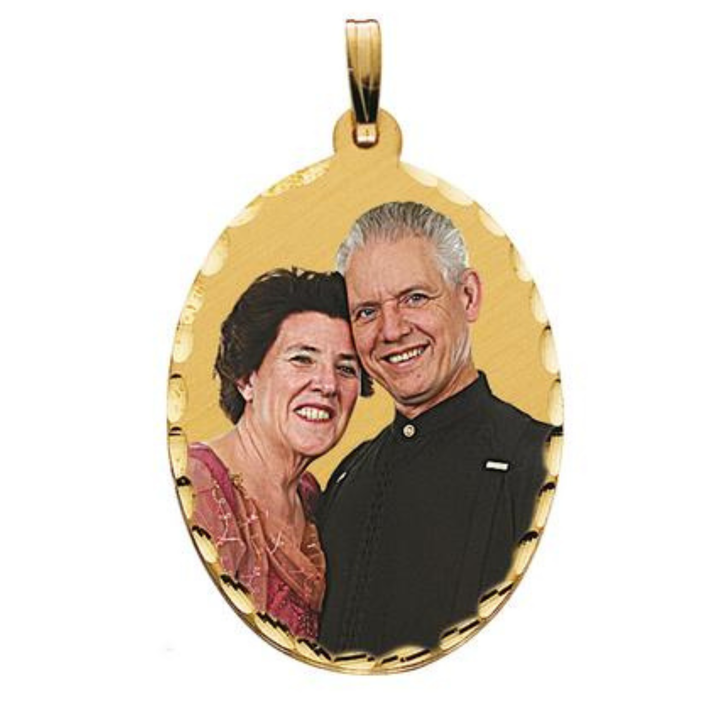 An oval gold pendant charm featuring a picture of a smiling couple, complete with a gold bail at the top, shown on a plain white background.