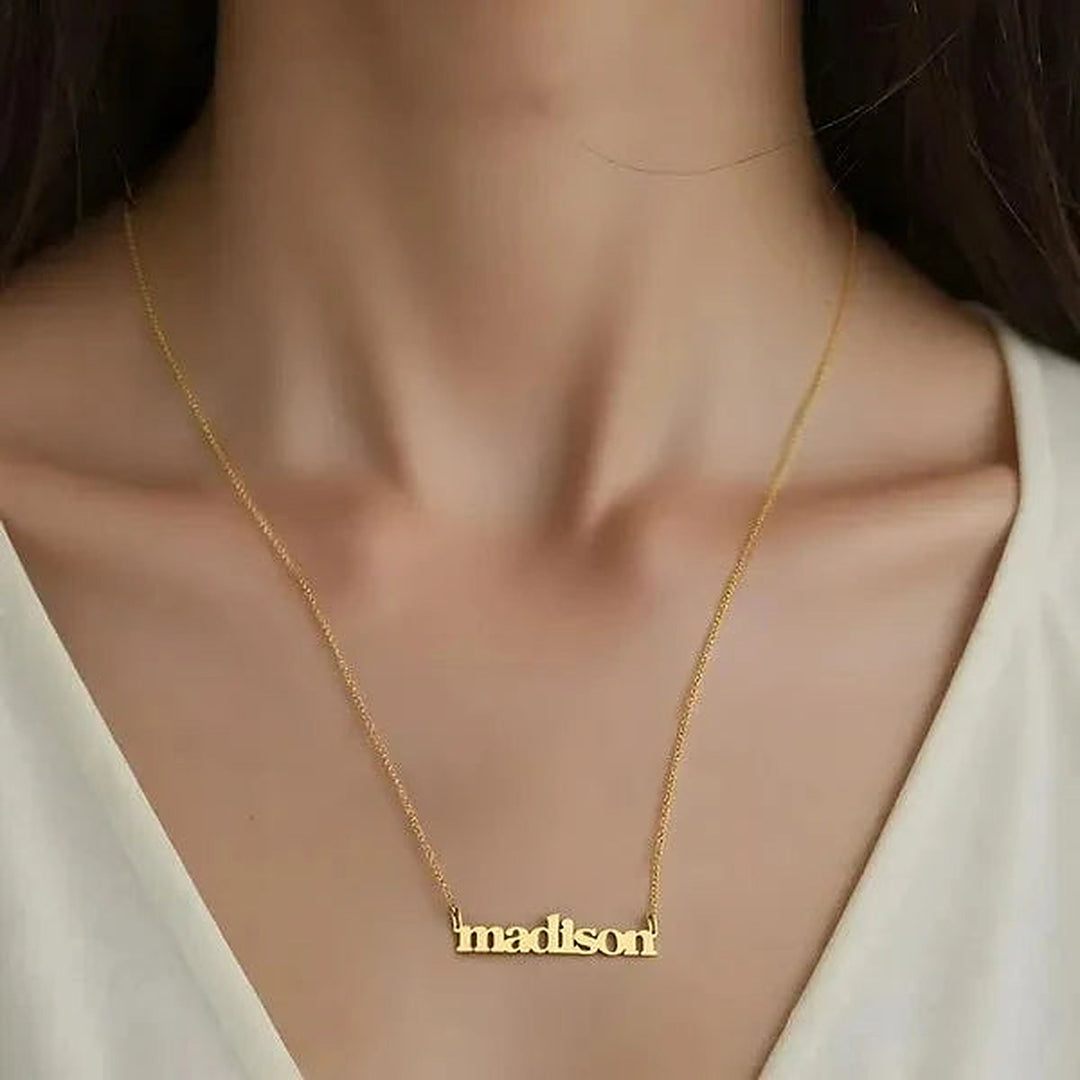 Model wearing the 14 Karat Lowercase Bold Name Necklace in 14K yellow gold personalized with the name Madison | AJ's Jewelry