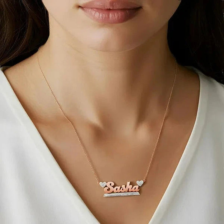 Model wearing the 14 Karat Bold Name Necklace with Two Hearts in 14K rose gold personalized with the name Sasha | AJ's Jewelry