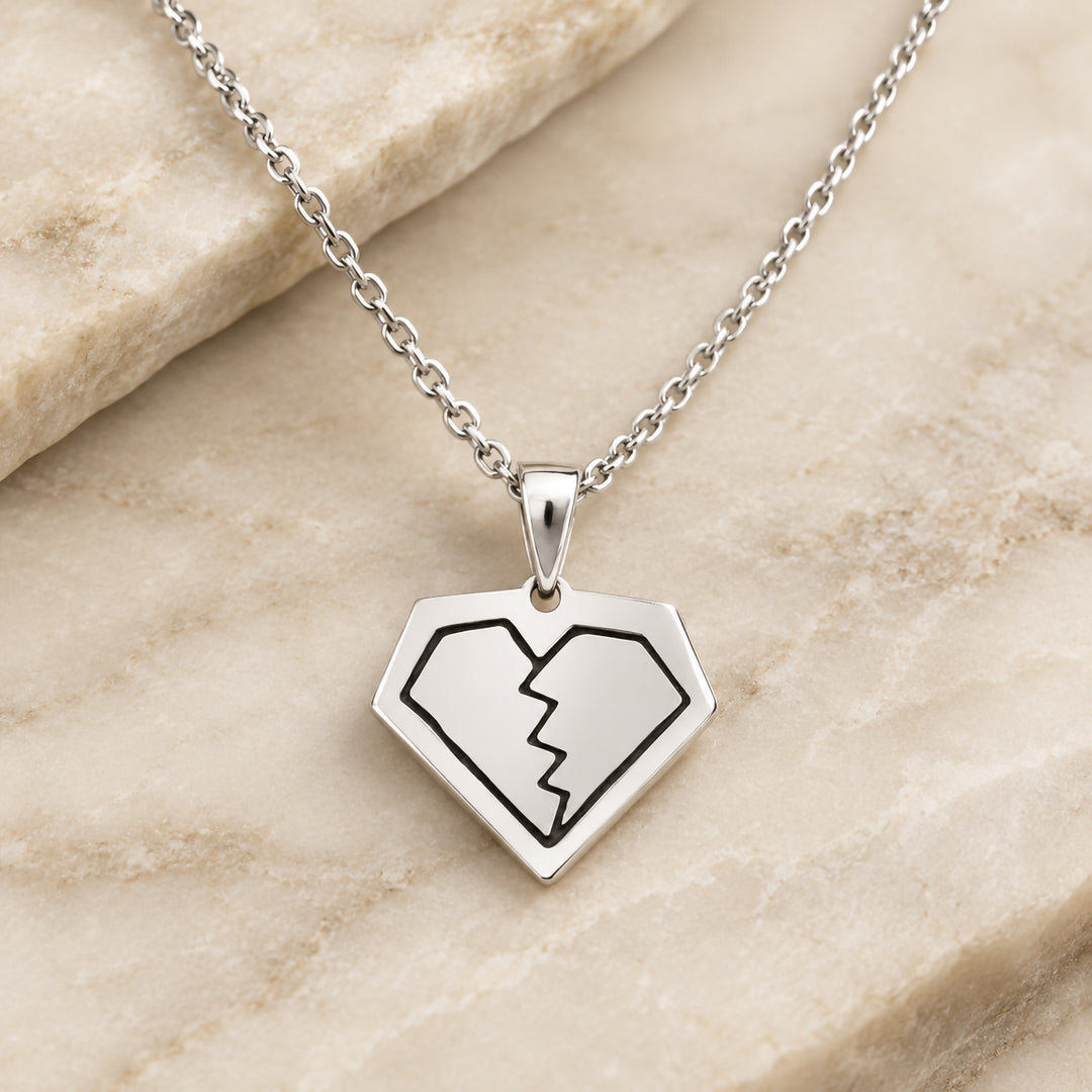 Finished sterling silver broken diamond pendant with black enamel filled linework, hanging on its chain